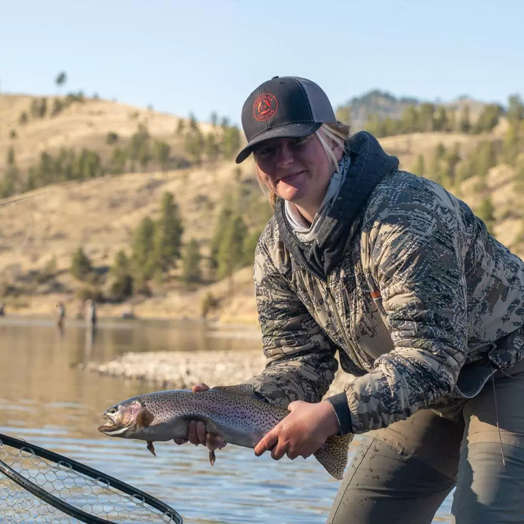 Fly Fisher in Montana Casting Co. Hat Holding Rainbow Trout