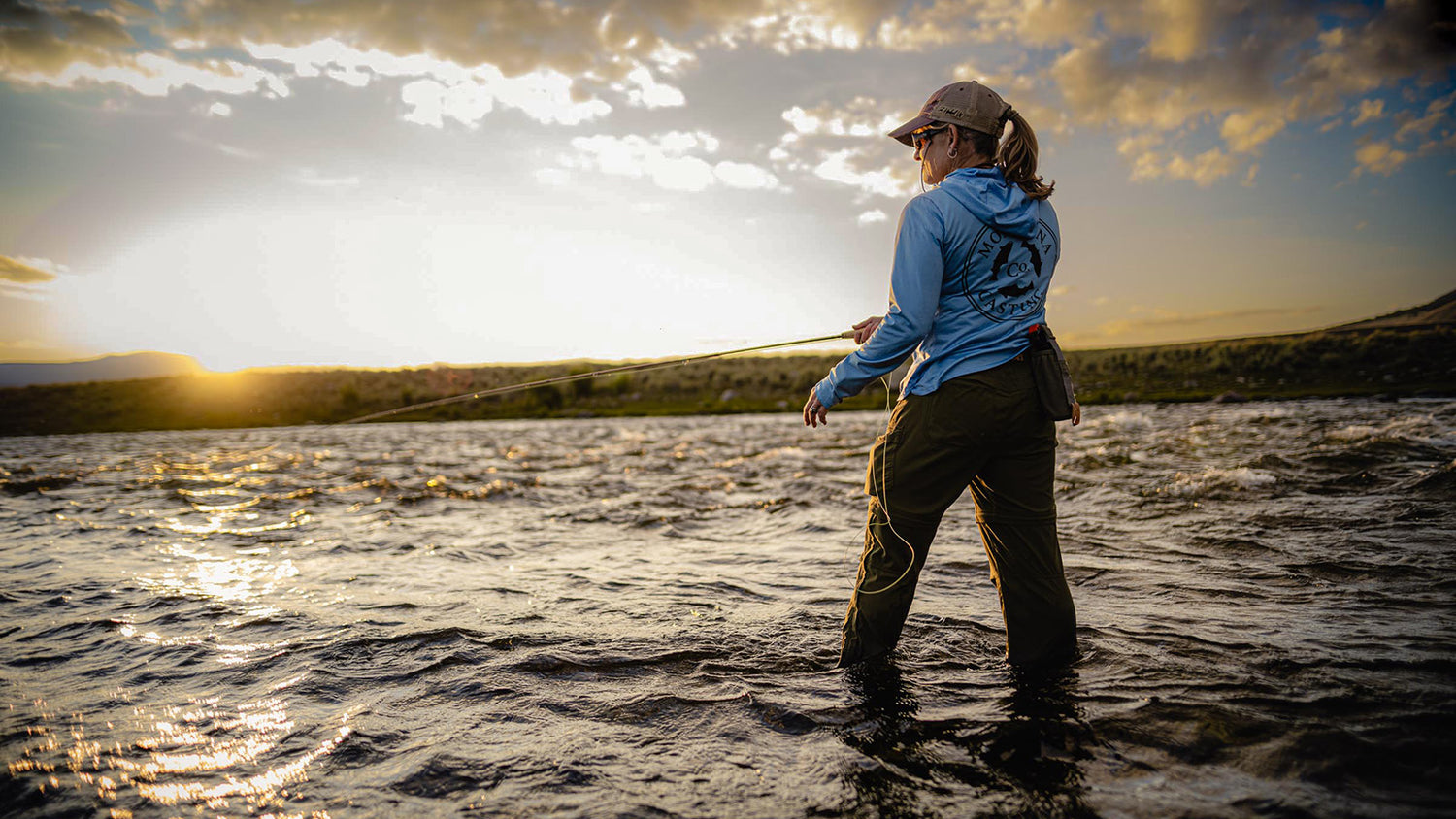 Fly Fisher Fishing on a River at Sunset