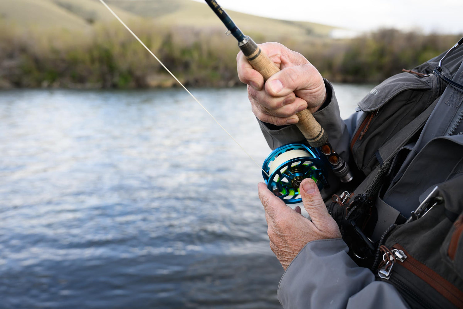 Person fishing with a fly fishing rod and reel on a Montana river
