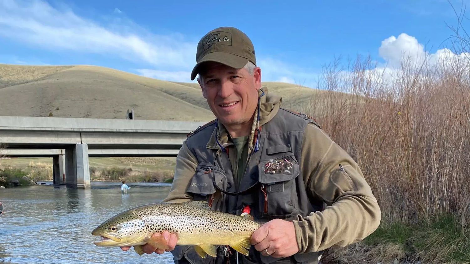 A Fly Fisherman Poses with a Large Trout