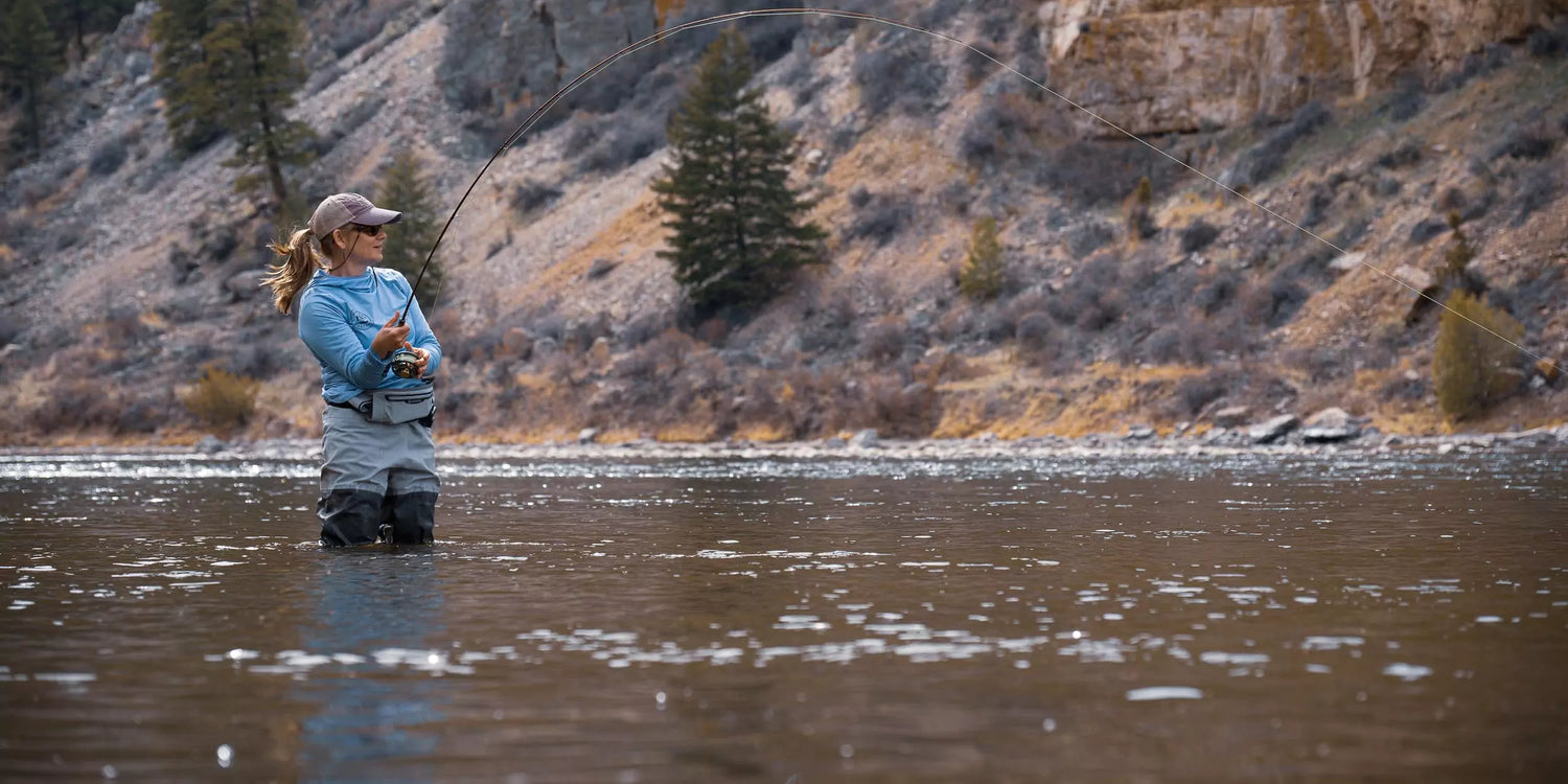 Woman Reeling in a Fish with Her Fly Rod and Reel