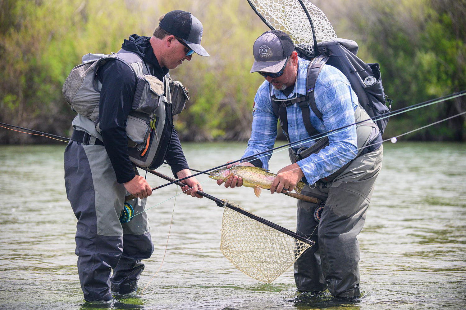 Two men with Montana Casting Co. Fly Rods holding a net and a trout