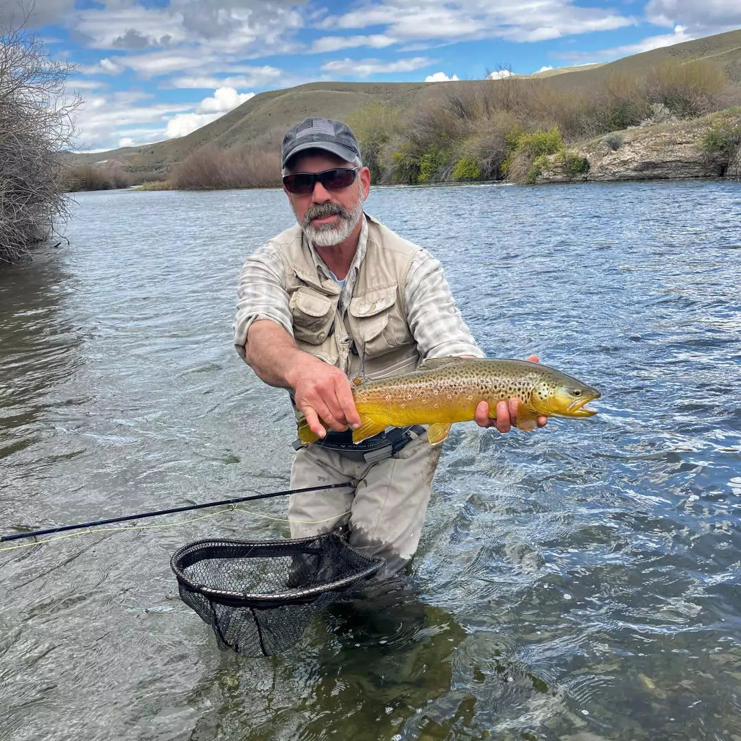 Man With A Fly Rod Holding a Brown Trout