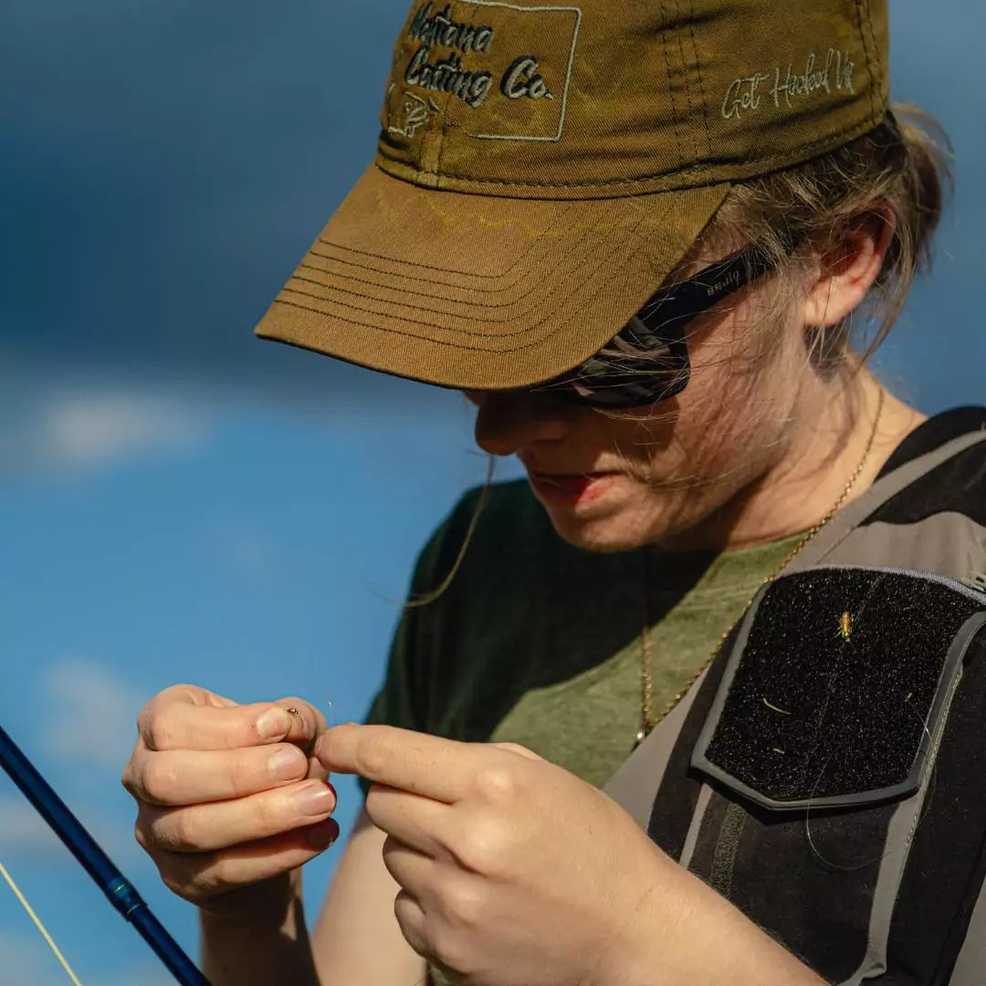 Woman Tying a Fly onto MCCo. Tippet