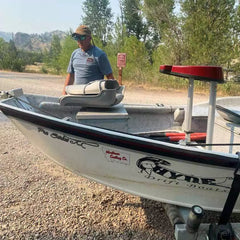 Man Standing Near Drift Boat with Montana State Decal